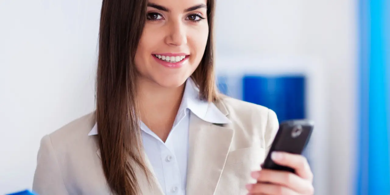 Mulher profissional sorrindo enquanto usa smartphone