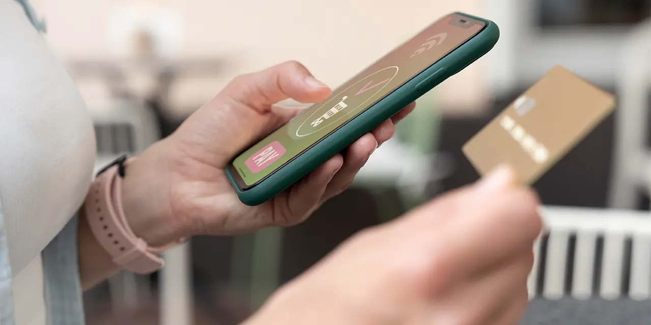 Profissional utilizando cartão NFC como cartão de visita digital para compartilhar suas informações de contato.