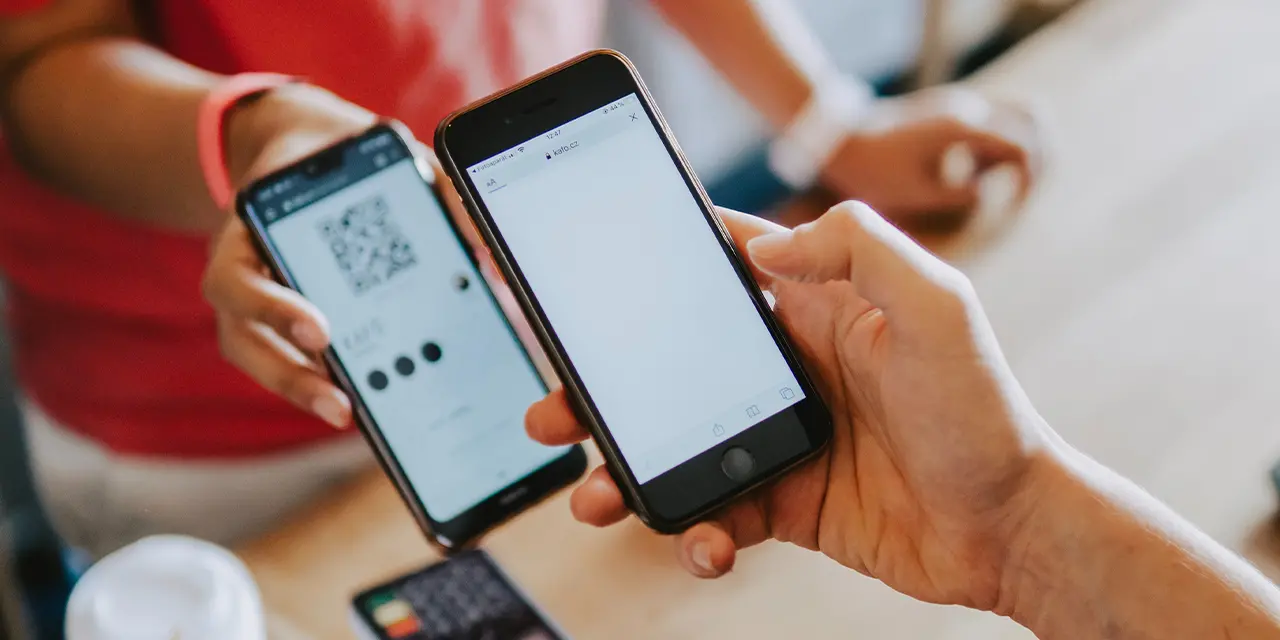 Pessoas utilizando QR Code para compartilhar informações de contato.