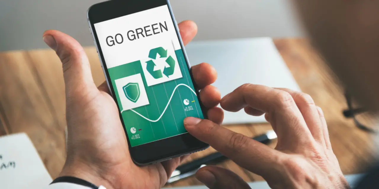 Pessoa usando smartphone com mensagem “Go Green” e ícone de reciclagem.